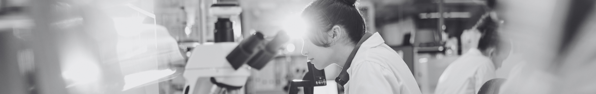 Lab Startup and Optimization Services lab technician working at a microscope