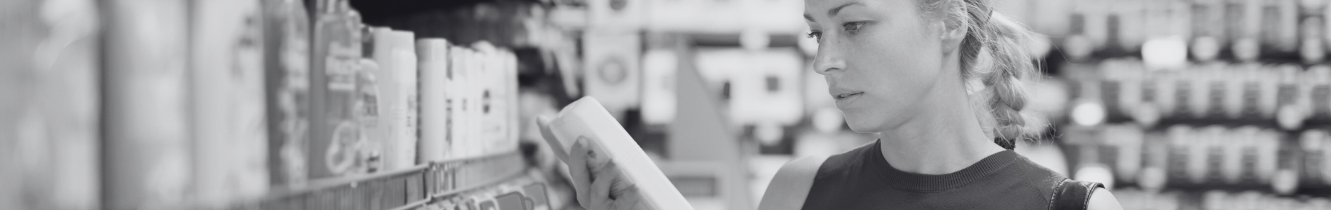 Consumer Product Safety Banner woman looking at an item (shampoo, conditioner, or body wash) from a shelf in a store